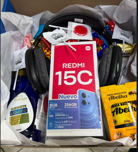 Foto enviada pela organização: caixa do Redmi 15C entre os brindes da Rádio Colmeia
